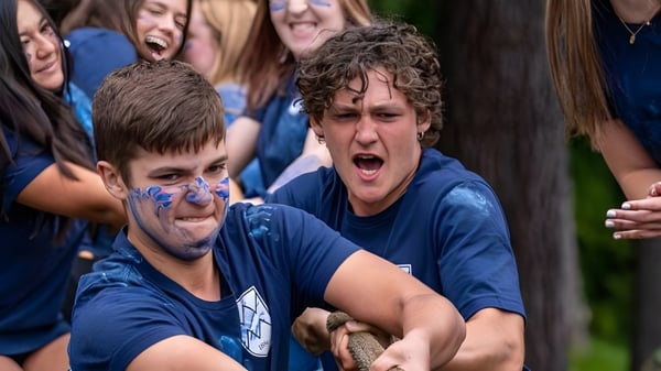 Estudiantes de la White Mountain School celebran al aire libre con caras pintadas en un evento animado.