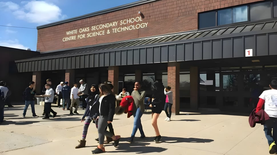 Los estudiantes están frente al edificio del White Oaks Secondary School Centre for Science & Technology.