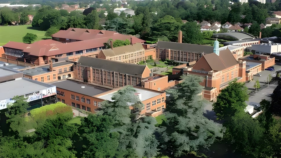 Toma aérea del histórico complejo de edificios de ladrillo en el terreno de la Whitgift School rodeado de mucho verde.