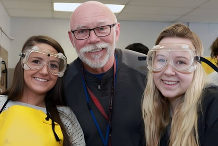 Tres personas, dos mujeres y un hombre, están en un pasillo de la William Aberhart High School y posan para una imagen grupal.