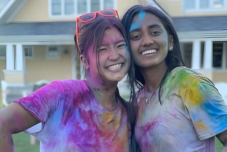 Dos estudiantes de la The Williston Northampton School están riendo frente a un edificio con ambiente festivo.