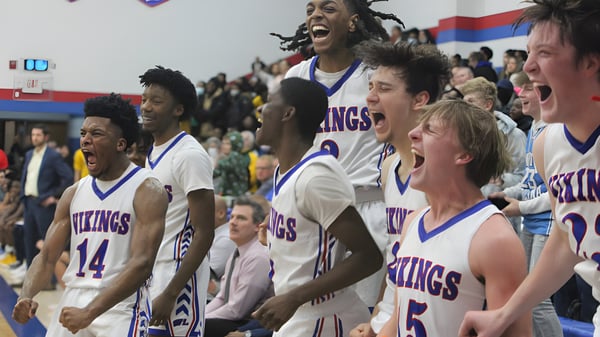 Estudiantes de la Wisconsin Lutheran High School celebran juntos en la cancha de baloncesto frente a los espectadores.