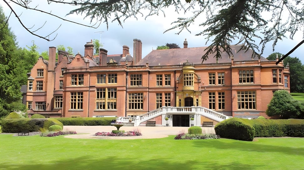 El magnífico edificio de ladrillo de la Woldingham School está rodeado de un jardín bien cuidado con césped verde.