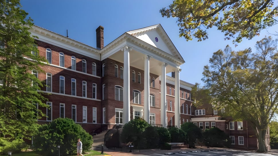 El edificio de ladrillo con columnas blancas de la Woodberry Forest School está rodeado de un exuberante verde.