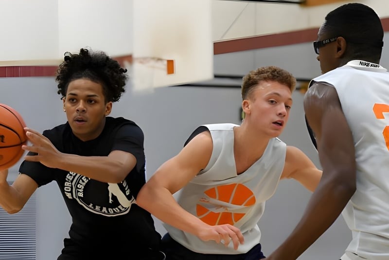 Tres jóvenes jugadores y jugadoras de baloncesto entrenan en la cancha de baloncesto de la Worcester Academy.