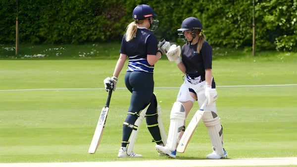 Dos estudiantes en uniforme de cricket están en el campo en el campus del Wrekin College.