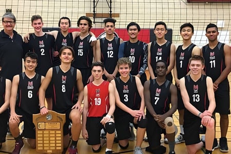 El equipo de voleibol del York Mills Collegiate Institute posa con un trofeo en el gimnasio.